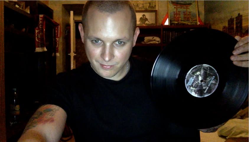 A member of the label holding a Harder & Louder vinyl record